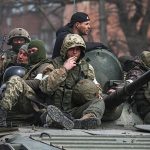 Anggota layanan pasukan Pro Rusia terlihat di atas kendaraan lapis baja selama konflik Ukraina-Rusia. Sumber foto : Reuters.
