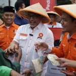 Ketua DPP PKS Bidang Tani dan Nelayan, Riyono Caping dan Presiden PKS Ahmad Syaikhu dalam aksi berbagi 1.000 paket sayuran dan 300 paket ikan asin kepada masyarakat di sekitar kantor DPTP PKS, Jakarta Selatan, Rabu (19/3/2025).